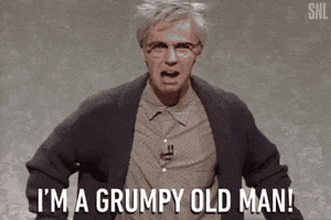 SNL gif. Dana Carvey dressed as Grumpy Old Man sits up in his seat with a droopy frown and tightly knotted eyebrows on his face. He shouts, “I'm a grumpy old man!”