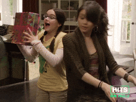 Sponsored GIF. Modern Family: The 3 young Dunphy children are standing in a living room. Wrapped presents in hand, they turn, reveal each of their packages and exclaim with excitement and happiness, "Happy Mother's Day!"