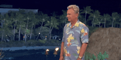 TV gif. Wearing a Hawaiian shirt, Pat Sajack on Wheel of Fortune shakes his head and throws his hand in the air as if to say, “Forget it.”