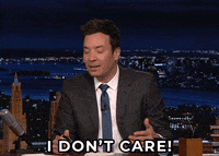 Late Night gif. Jimmy Fallon sits at his desk, squinting his eyes and shaking his head as he says, “I don't care.”