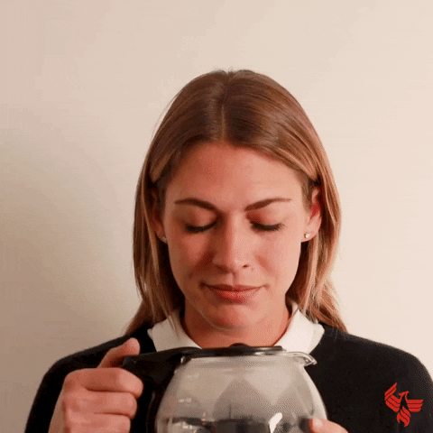 Video gif. A woman holds a pot of coffee and pops opens the lid while staring into it. She lifts it to her mouth and chugs directly from the pot.
