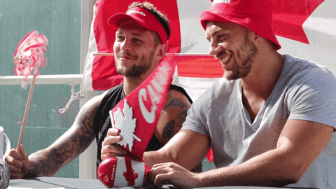 Two men wearing Canada’s accessories are laughing.