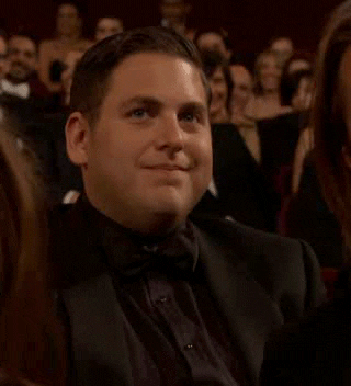Celebrity gif. At an awards show in the audience, Jonah Hill shakes his head and motions with his hand to his throat in a "cut it out" motion.