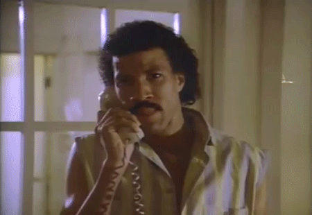 Celebrity gif. An emotional Lionel Richie sings into the phone, “Hello? Is it me you're looking for?” A woman on the other line lies in bed in her pajamas, holding the receiver to her ear and smiling.