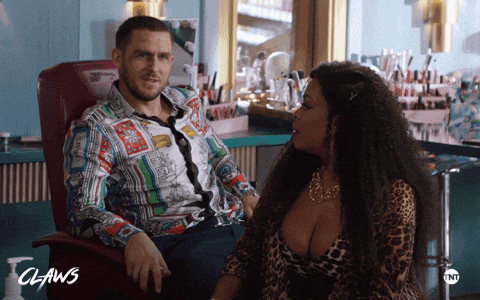 TV gif. Jack Kesy as Roller on Claws pumps his fists in front of his face while talking as Niecy Nash as Desna watches him, then looks forward, confused.
