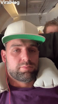 Crying Child Peeks Over Plane Seat
