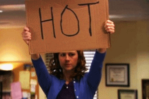 The Office gif. Jenna Fischer as Pam Beesly stands and rotates with a cardboard sign that says "hot" in capital letters.