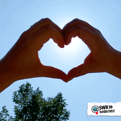 Video gif. Two hands forming a heart, against a blue sky, sun shining through.