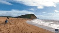 Cliff Collapses Into Sea Near People Walking Along the Beach in Dorset