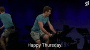 Video gif. Though the rest of the room is dark, a man riding an exercise bike in a blue t-shirt and shorts is lit clearly. He swings his head toward us emphatically to exclaim: Text, "Happy Thursday!"