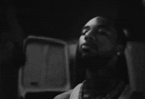 Music video gif. From the video for Paper Route Empire's "Let's Go," a black-and-white shot of Key Glock in a melancholy room staring at his reflection and looking down. 