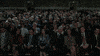 Movie gif. We see a large audience start applauding enthusiastically. We move up higher as balloons float up from the crowd, people stand, and acrobats come down from the ceiling.