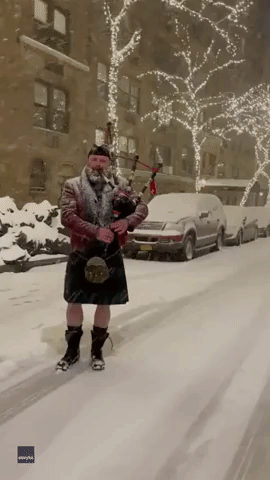 Bagpiper Performs 'Come All Ye Faithful' Illuminated by Manhattan's Christmas Lights