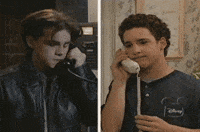 TV gif. A split screen phone conversation of Ben Savage as Cory and Rider Strong as Shawn in Boy Meets World, each lowering the phone receiver sadly, then both return it to their ear, listening hopefully.