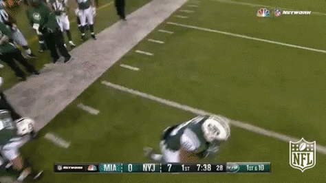 Sports gif. Matt Forte of the New York Jets runs from the sidelines to the center of the football field to join the rest of his teammates.