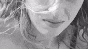Celebrity gif. Fletcher in black-and-white, looking down, dramatic and unsmiling.