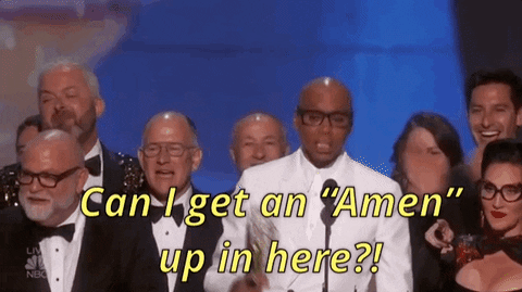 Celebrity gif. RuPaul in a white suit raises a gold award in the air. People cheer behind him. Text, "Can I get an 'Amen' up in here?!"