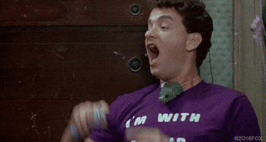 TV gif. Wearing a purple T-shirt, a younger Tom Hanks puts a can of silly string up to his nose and pretends it's snot as he sprays it on an unamused child.