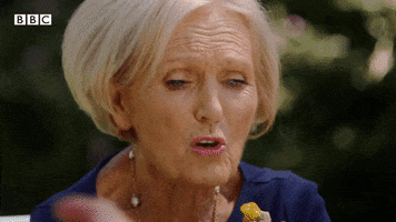 TV gif. Celebrity chef Mary Berry eats a small pastry.