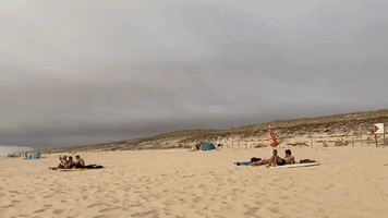 Wildfire Smoke Shrouds Sun on French Beach Amid Soaring Temperatures