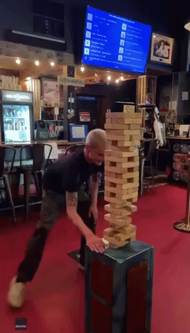 Guy's Risky Move Does Not Pay Off During Game of Giant Jenga at Florida Bar
