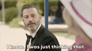Oscars 2024 GIF. Jimmy Kimmel sits next to Margot Robbie as Barbie on the bus stop bench. He parodies the bus stop bench scene and leans in and enthusiastically says, "I know. I was just thinking that."