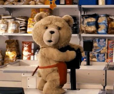 Movie gif. Ted the Teddy Bear in the movie Ted wears a red apron and stands on a check out counter. He humps the card reader and looks at someone smiling.