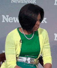 Celebrity gif. Michelle Obama turns towards us with a smirk as she gives a carefree thumbs up. 