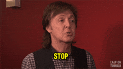Tonight Show gif. Paul McCartney waves his pointer finger and says, “Stop.”