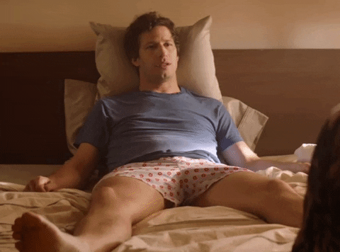 Movie gif. Andy Samberg as Nyles in Palm Springs lays in bed appearing depressed, propped up on a pillow, and says "Kill me," which appears as text.