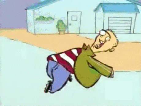 Cartoon gif. Ed with one d on Ed, Edd, and Eddy runs excitedly down the street. He runs leaning back with his arms loosely catching in the wind. His mouth is open in a big smile with his tongue sticking out. 