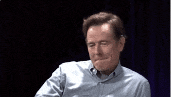 Celebrity gif. Bryan Cranston purses his lips as he leans to the side and casually drops a microphone.