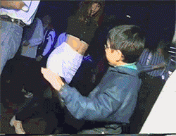 Video gif. A child in sunglasses busts some moves among adults at a dance party.