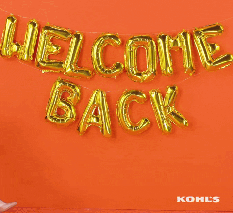Ad gif. A wall with a balloon sign saying "WELCOME BACK," is displayed and a woman sitting in an office chair is pushed into frame. There are happy face balloons tied to her chair and she gives a wide smile while raising her arms in the air in excitement.