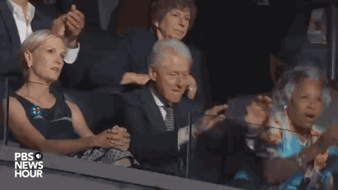 Political gif. Bill Clinton stands in applause giving Bernie Sanders a standing ovation. 