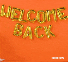 Ad gif. A wall with a balloon sign saying "WELCOME BACK," is displayed and a woman sitting in an office chair is pushed into frame. There are happy face balloons tied to her chair and she gives a wide smile while raising her arms in the air in excitement.