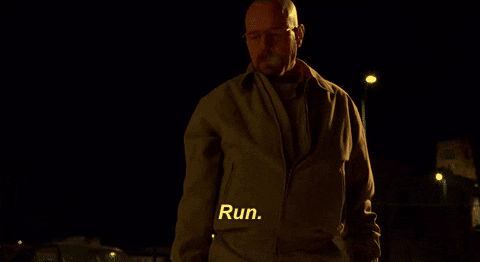 TV gif. Zoom in on Bryan Cranston as Walter White on Breaking Bad as he stands in the dark of a cold night. He looks intimidatingly up at someone as condensation breathes out of his mouth like smoke as he says, “Run.”