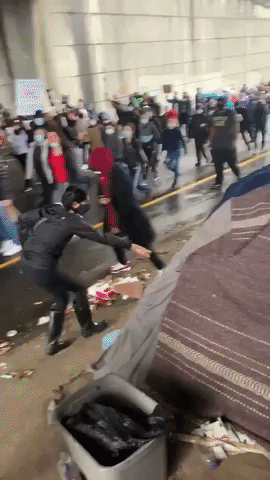 Protesters Hand Food to Homeless Person During Seattle March