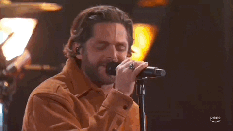 Academy of Country Music Awards gif. Man in brown button up sings intensely with forehead vains showing and eyes closed and swaying head from side-to-side.