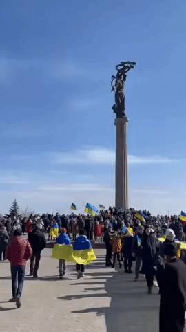 Protesters Carry Large Ukrainian Flag Past Armored Vehicles in Kherson