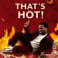 Sponsored gif. Man lies on his side in a suggestive pose on a giant slice of pepperoni pizza. Flames dance behind him. He winks and points upward at floating text that reads, “That’s hot!”