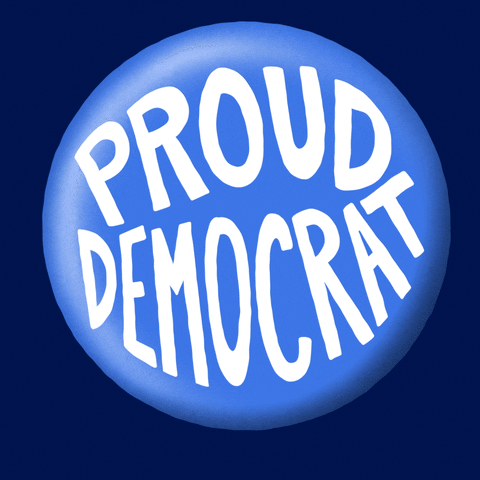 Digital art gif. Large, shiny blue button with the words "Proud Democrat" on it rotates side to side against a dark blue background.
