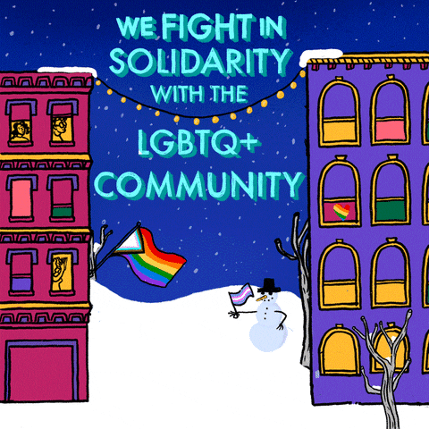 Illustrated gif. Snowy urban scene of two apartment buildings, people in the windows, a Quasar pride flag displayed off of one building, a Baker pride flag hanging in a window of the other, the peaceful alley between them offers a view of a park, with a man walking his dog, a girl pulling a child on a sled, and a snowman holding a Transgender pride flag. Text, "We fight in solidarity with the LGBTQ+ community."