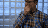 Video gif. A man puts his hands on his chin in a thinking position and rubs hard, thinking long and deep.