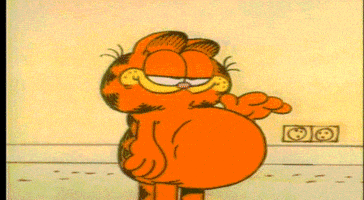 Cartoon gif. Garfield patting his unusually large belly and smiling.
