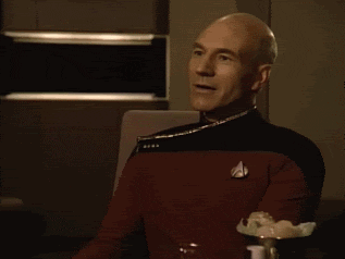 TV gif. Patrick Stewart as Picard in Star Trek shakes his head slightly, looking proud and smiling as he slow-claps.