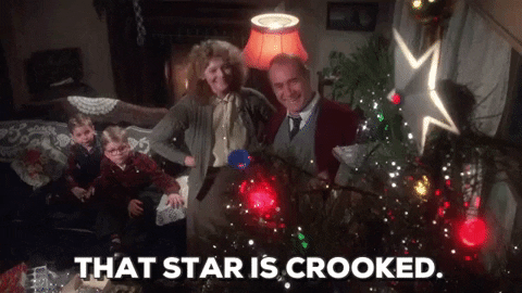 Movie gif. A high-angle shot of the Parker family from A Christmas Story in their living room, admiring their decorated Christmas tree. Darren McGavin as Old Man Parker speaks. Text, "That star is crooked."