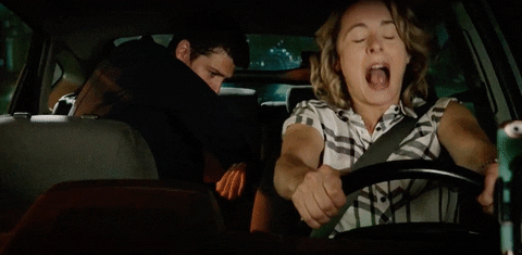 Celebrity gif. Heather Anne Campbell drives a car and firmly grasps the steering wheel. She screams out in terror. Leroy Patterson is awkwardly sitting in her back seat and he looks up in shock as she screams. 