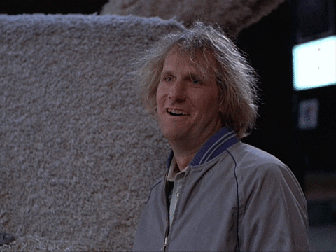 Movie gif. Jeff Daniels as Harry on Dumb and Dumber blinks and smiles as if blown away. Text, "Cool."