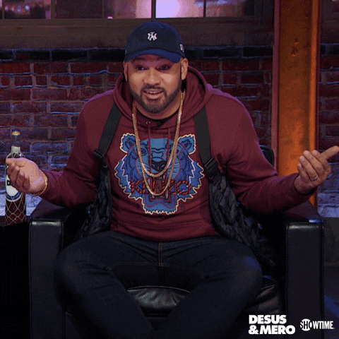 TV gif. The Kid Mero on Desus & Mero holds his hands out in question and then slumps back in his chair, one hand gesturing towards someone off screen with a skeptical look. 